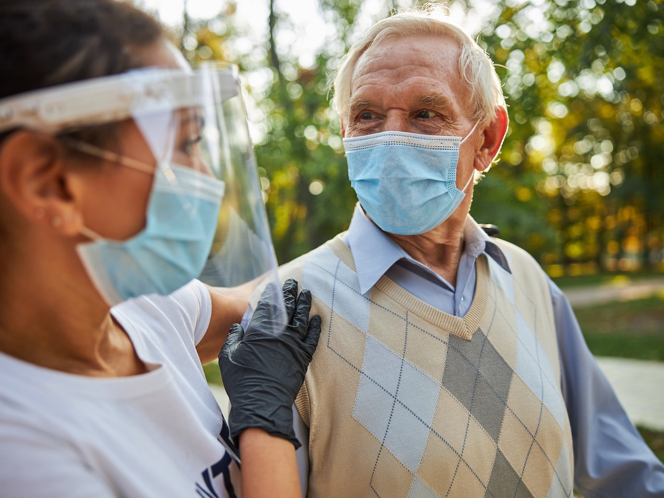 senior man looking to the eyes of female in medicine mask